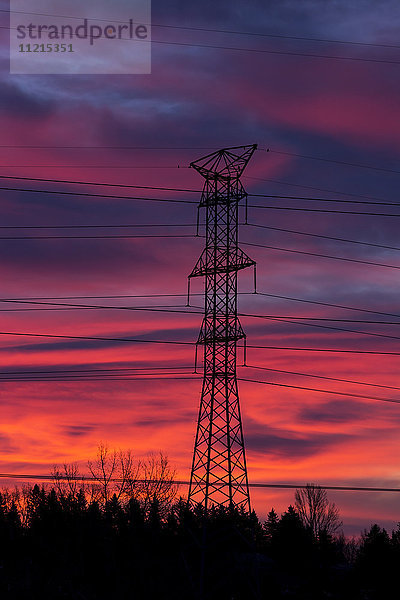 Silhouette eines hohen Metall-Elektroturms mit buntem  dramatischem Himmel bei Sonnenaufgang; Calgary  Alberta  Kanada'.