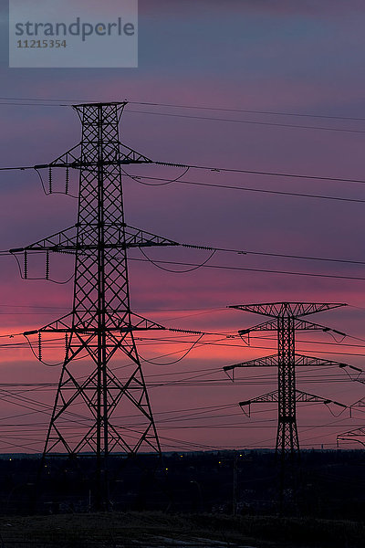 Silhouette eines hohen Metall-Elektroturms mit buntem  dramatischem Himmel bei Sonnenaufgang; Calgary  Alberta  Kanada'.