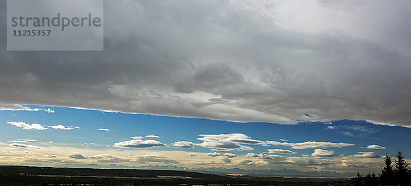 Dramatisches Panorama einer Chinook-Bogenwolke mit blauem Himmel und Silhouette einer Bergkette am Horizont; Calgary  Alberta  Kanada'.