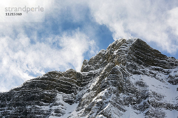 Schneebedeckter Berggipfel mit wogenden Wolken und blauem Himmel; Alberta  Kanada'.