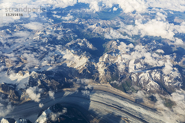 Luftaufnahme von Wolken  die sich zwischen den schneebedeckten Gipfeln der Alaska Range winden  im Inneren Alaskas; Alaska  Vereinigte Staaten von Amerika'.