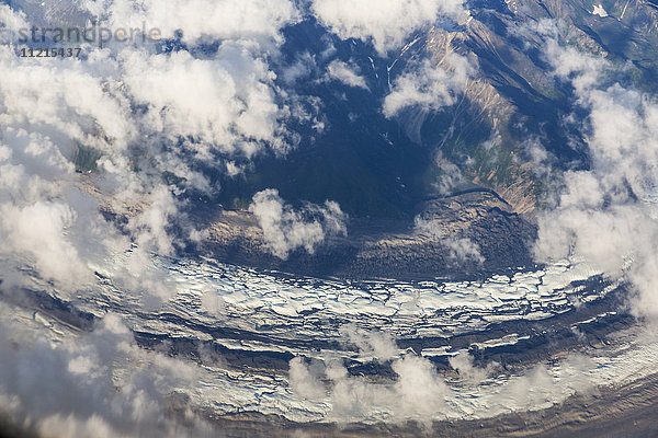 Luftaufnahme von Wolken  die sich zwischen den schneebedeckten Gipfeln und Gletschern der Alaska Range  im Inneren Alaskas  winden; Alaska  Vereinigte Staaten von Amerika'.
