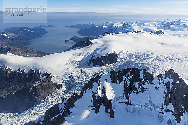 Luftaufnahme des Harding-Eisfelds und der Gletscher  die von den schneebedeckten Gipfeln herunterkommen  Prince William Sound im Hintergrund  Kenai-Halbinsel  Süd-Zentral-Alaska; Seward  Alaska  Vereinigte Staaten von Amerika'.