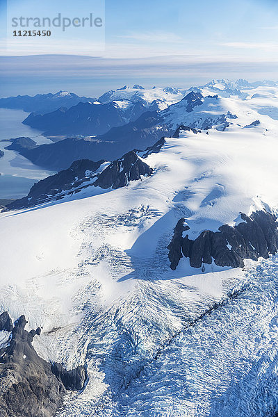 Luftaufnahme des Harding-Eisfelds und der Gletscher  die von den schneebedeckten Gipfeln herunterkommen  Prince William Sound im Hintergrund  Kenai-Halbinsel  Süd-Zentral-Alaska; Seward  Alaska  Vereinigte Staaten von Amerika'.