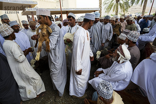 Traditionell gekleidete Männer bieten auf dem freitäglichen Ziegen-Souk