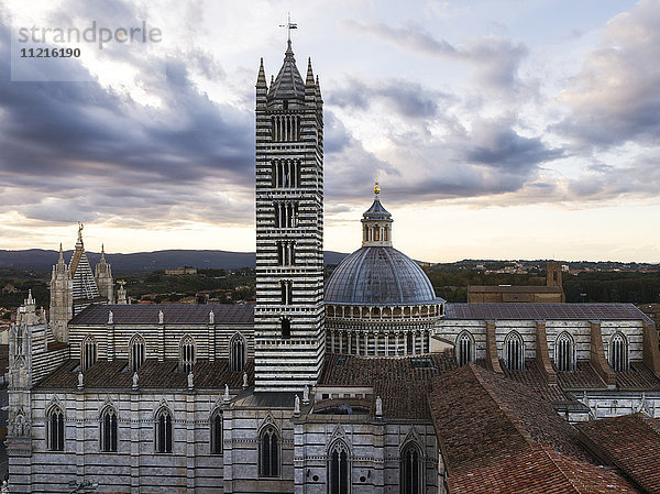 Gestreifte Fassade eines Turms und Kuppeldach des Doms von Siena; Siena  Italien'.