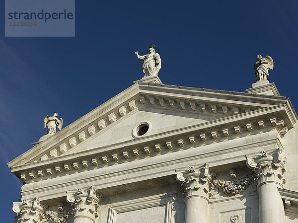 Weiße Fassade eines Gebäudes mit Statuen menschlicher Figuren auf dem Dach; Venedig  Italien
