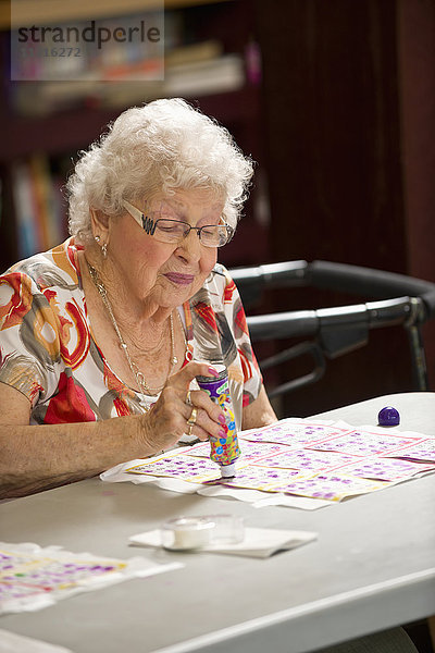 Eine ältere Frau spielt Bingo; Devon  Alberta  Kanada'.
