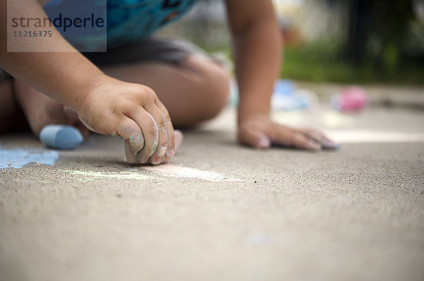 Kind spielt mit Straßenkreide; Regina  Saskatchewan  Kanada'.
