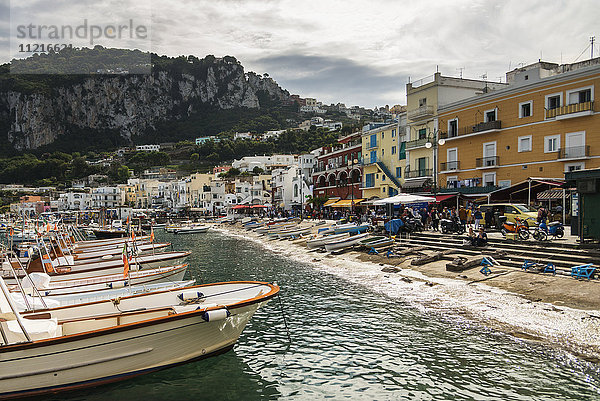 Aneinandergereihte Boote im Hafen mit farbenfrohen Gebäuden entlang der Uferpromenade; Capri  Kampanien  Italien