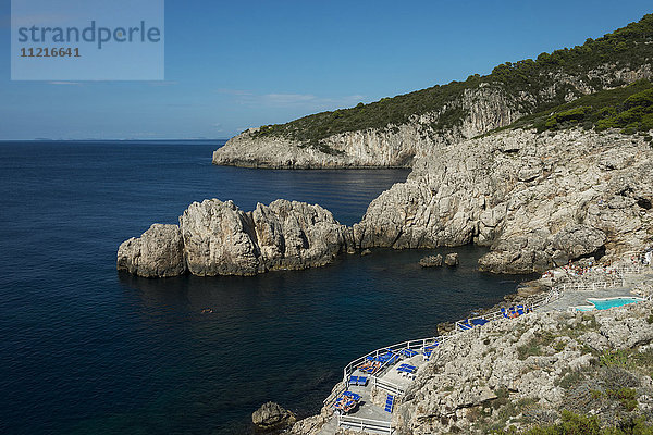 Zerklüftete Küste der Insel Capri  mit einem Balkon voller blauer Stühle; Capri  Kampanien  Italien