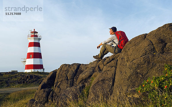 Wanderer mit Blick auf den Leuchtturm von Brier Island  Brier Island  Bay of Fundy; Nova Scotia  Kanada'.