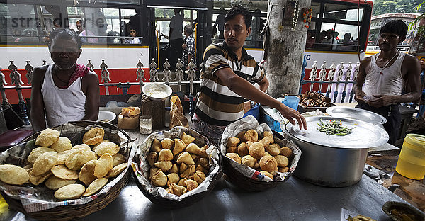 Indische Männer verkaufen herzhafte Snacks an einem Straßenstand