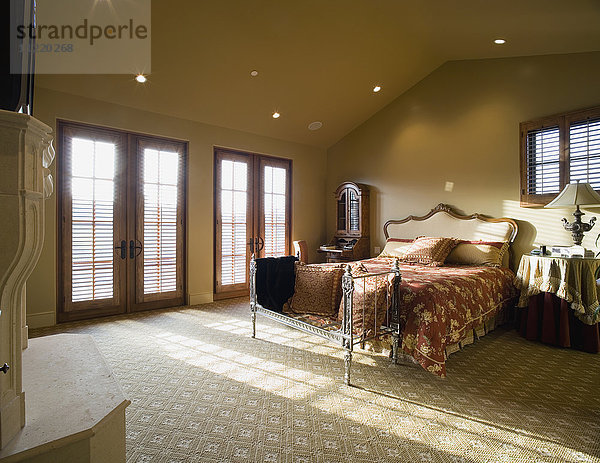 Hauptschlafzimmer mit gewölbter Decke und Fensterlicht  das durch doppelte Fenstertüren fällt