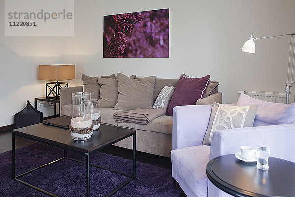 Couchtisch auf lila Teppich im modernen Wohnzimmer