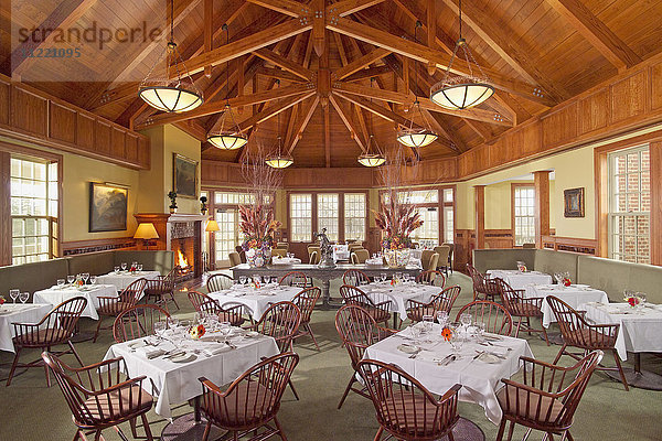 Großer Speisesaal mit mehreren Tischen und Holzdecken
