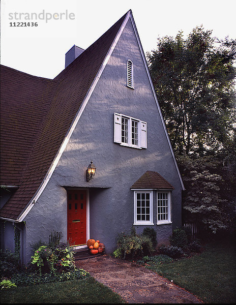 Außen graues Haus im Landhausstil mit Spitzdach und roter Tür in Chico