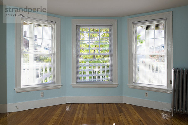 Leeres Zimmer in einer Wohnung mit Parkettboden und Heizung