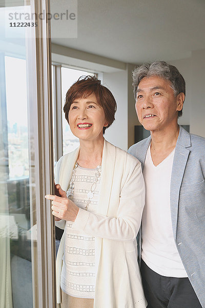 Modisches japanisches Seniorenpaar am Fenster