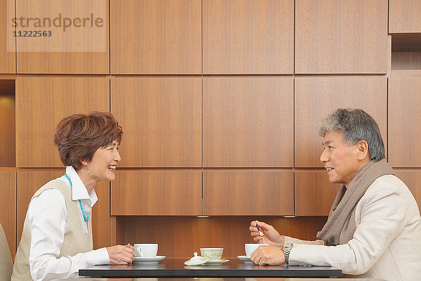 Modisches japanisches Seniorenpaar bei einer Tasse Kaffee