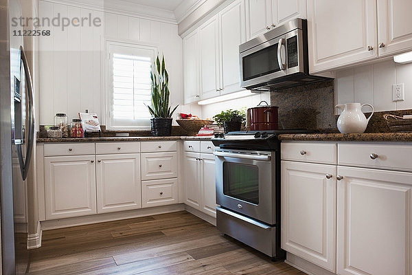 Blick auf eine Küche mit weißen Schränken zu Hause