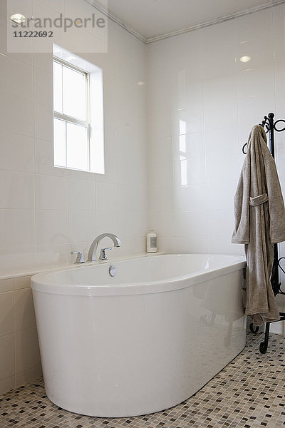 Blick auf ein Bad mit Bademantel auf einem Ständer im Badezimmer