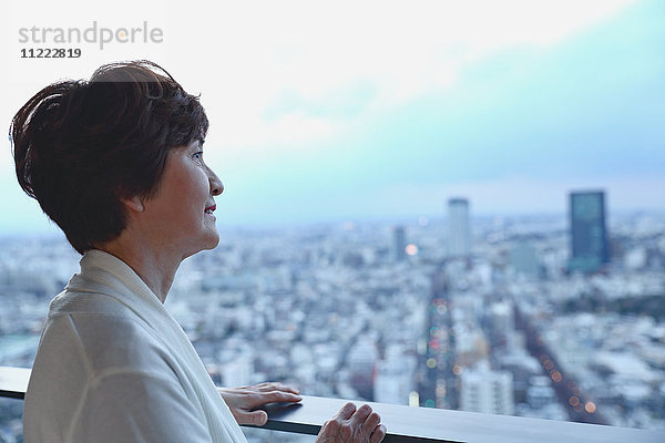 Modische japanische Seniorin mit Blick auf das Stadtbild von Tokio