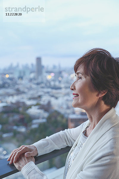 Modische japanische Seniorin mit Blick auf das Stadtbild von Tokio