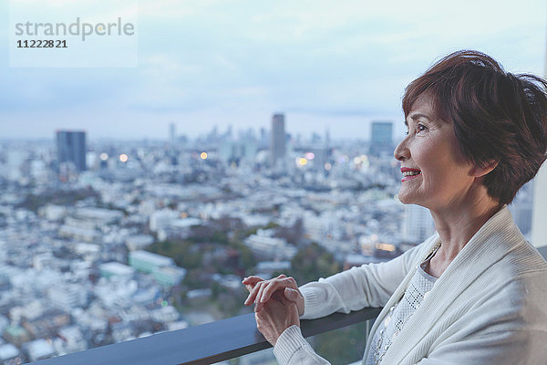 Modische japanische Seniorin mit Blick auf das Stadtbild von Tokio