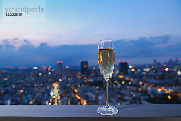 Ein Glas Champagner vor der Stadtkulisse von Tokio