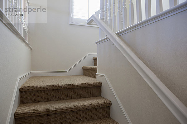 Nahaufnahme einer Treppe mit weißen Wänden zu Hause