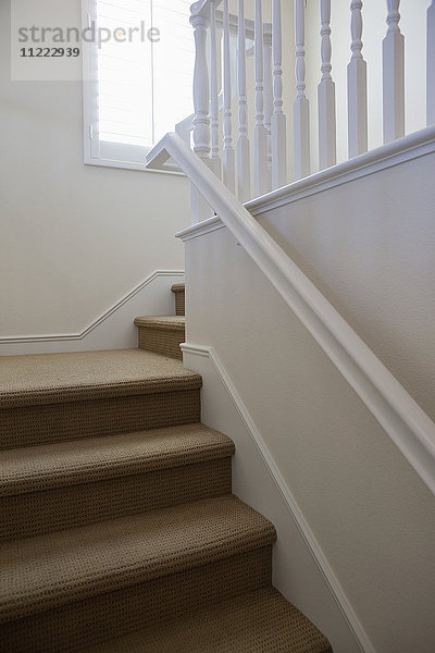 Nahaufnahme einer Treppe mit weißen Wänden zu Hause