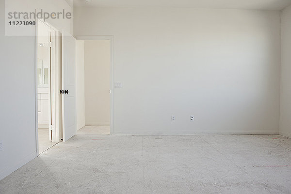 Leerer Raum mit Türöffnungen und weißem Boden