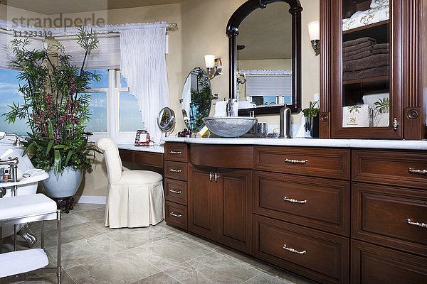 Badezimmer mit braunen Schränken und Spiegeln zu Hause