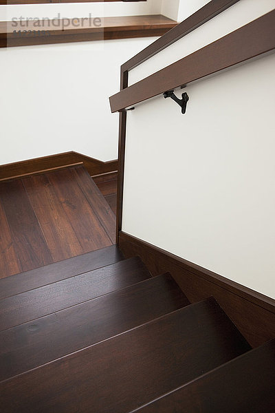 Hohe Winkelansicht einer Holztreppe mit Handlauf zu Hause
