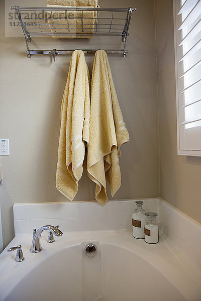 Badezimmer mit hängenden Handtüchern über der abgeschnittenen Badewanne