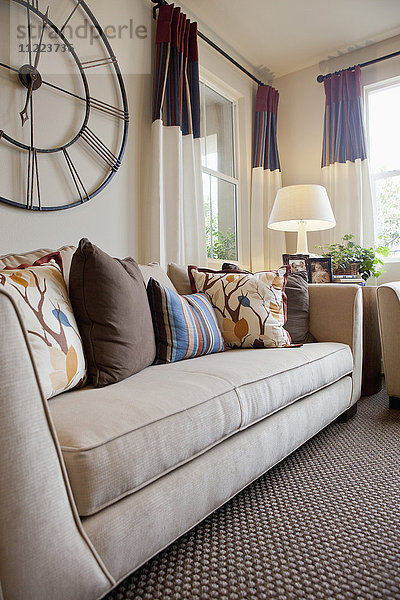 Couch mit großer Wanduhr im heimischen Wohnzimmer