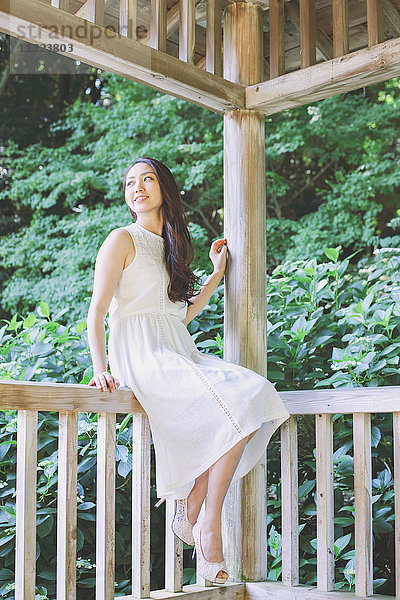 Junge Japanerin auf einem Holzdeck in einem Stadtpark