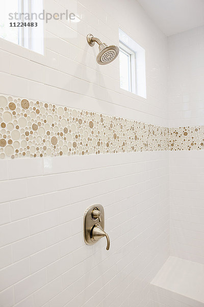 Dusche mit weiß gefliester Wand im häuslichen Badezimmer