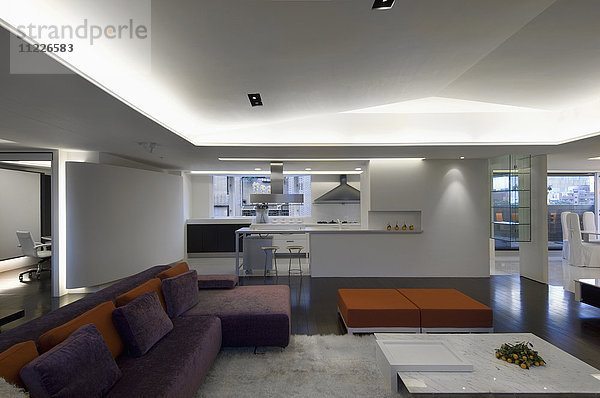 Geräumiges modernes Interieur mit lila und orangefarbenem Sofa