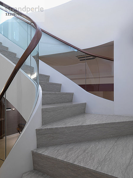 Blick auf halber Höhe der modernen Treppe mit Glasgeländer
