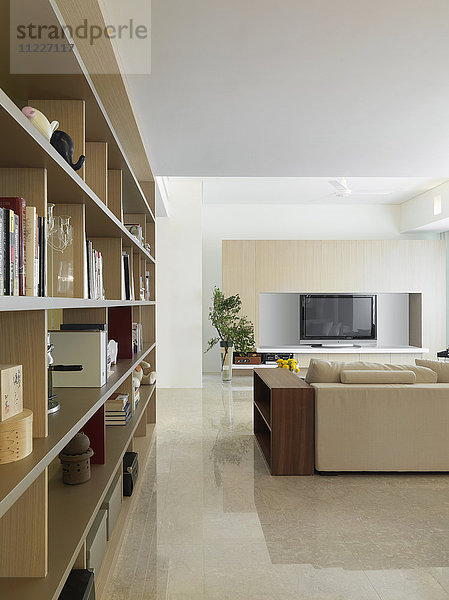Blick vom Bücherregal ins einfache Wohnzimmer