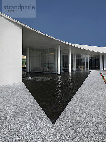 Dreieckiger Pool vor modernem Gebäude