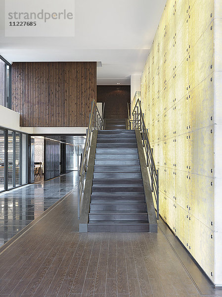 Moderne Treppe vor einer beleuchteten Wand