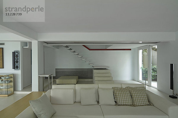 Sofa und schwebende Treppe in einem modernen Haus