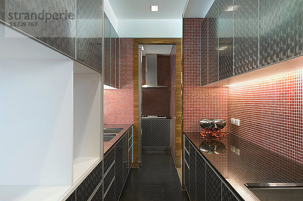 Moderne Küche mit Schränken und Mosaikfliesenwand