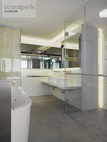 Badezimmer mit Glaswänden und -tür in einer modernen Wohnung