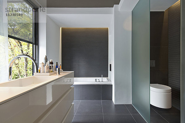 Modernes Badezimmer mit Badewanne und Kommode