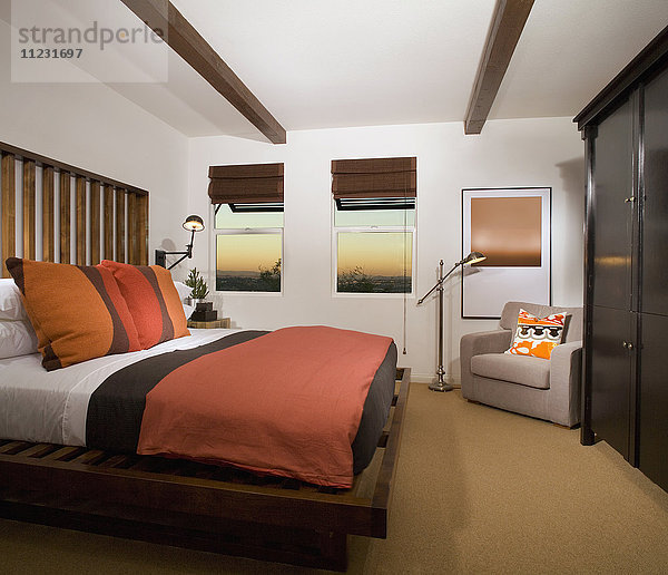 Gemütliches Schlafzimmer mit terrakottafarbener Bettdecke