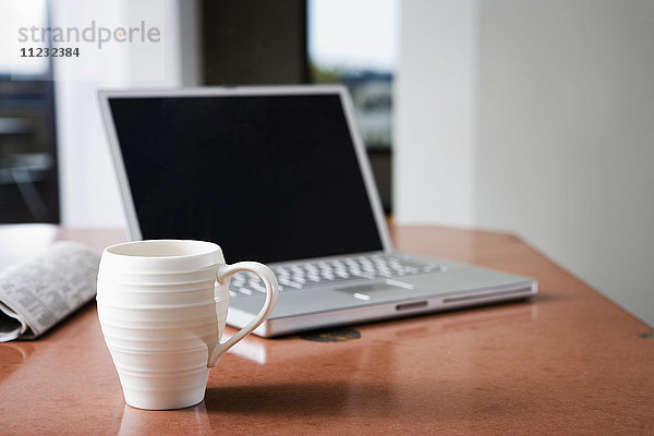 Laptop und Kaffeebecher